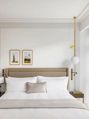 Helles Hotelzimmer mit großem Bett und minimalistischer Dekoration