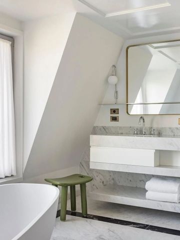 Helles Badezimmer mit Badewanne und Blick auf die Stadt