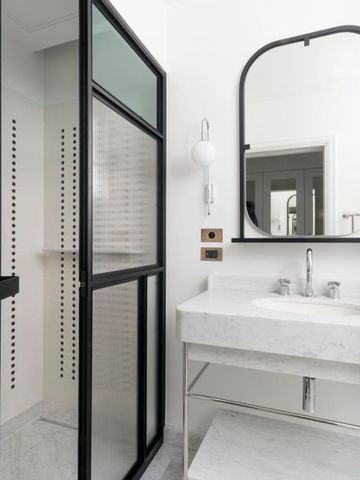 Elegantes Badezimmer mit Waschbecken und großem Spiegel.