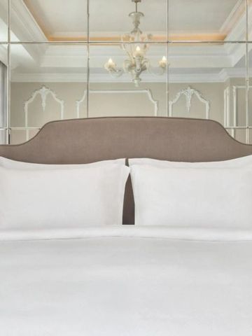 Detailaufnahme eines stilvollen Hotelbettkopfteils mit Spiegelwand