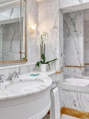 Badezimmer mit Marmordesign und moderner Armatur