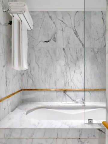 Marmorbadezimmer mit Eckbadewanne und Handtuchhalter