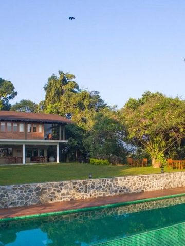 Hotelgebäude mit großen Veranda und Swimmingpool im Garten