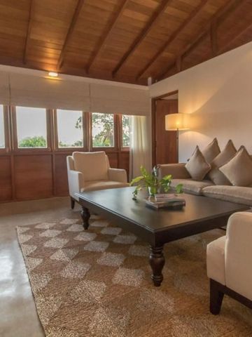 Elegantes Wohnzimmer mit großen Fenstern und gemütlichen Möbeln