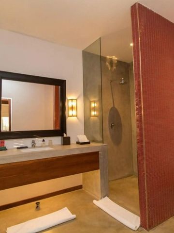 Modernes Hotelbad mit großer Dusche und stilvollen Leuchtkörpern