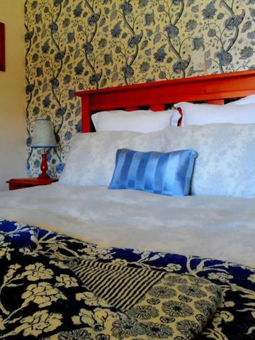 Nahaufnahme eines Doppelbetts mit floraler Decke in Kinloch Lodge