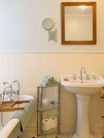 Elegantes Badezimmer mit freistehender Badewanne, Waschtisch und Spiegel