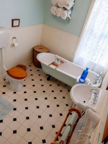 Historisches Badezimmer mit Vintage-Badewanne und klassischen Fliesen