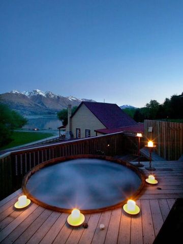 Outdoor-Whirlpool mit Kerzen und Bergblick bei Dämmerung
