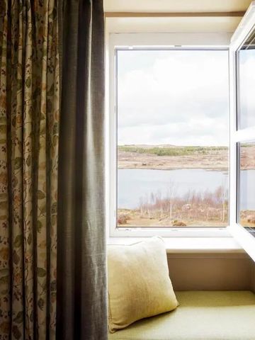 Offenes Fenster mit Blick auf eine ruhige Landschaft draußen