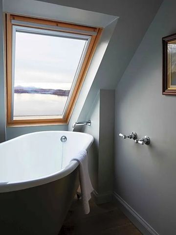 Badewanne mit Dachfenster und Blick auf die Landschaft im Kinloch Lodge Hotel