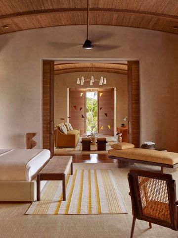 Geräumiges Schlafzimmer in warmen Tönen mit gemütlicher Sitzecke im Hintergrund