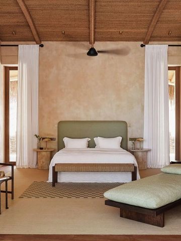 Elegantes Schlafzimmer mit Holzbalkendecke und natürlicher Einrichtung.