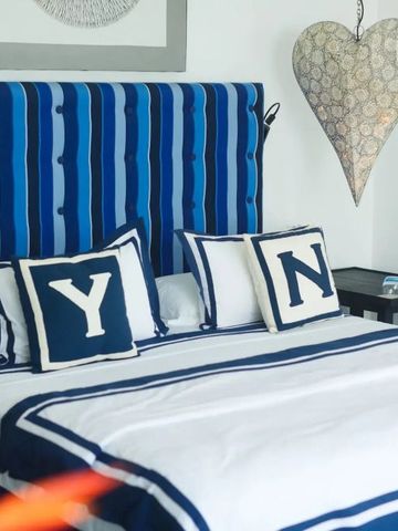 Geräumiges Hotelzimmer mit blau-weißem Dekor und herzförmiger Wanddekoration