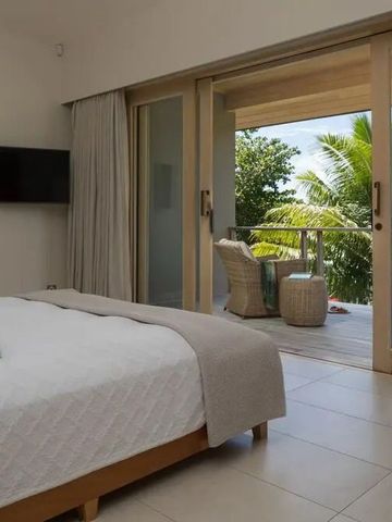 Helles Schlafzimmer mit Zugang zu einem privaten Balkon auf Kokomo Private Island.