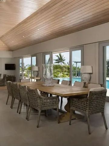 Eleganter Essbereich mit Blick auf den Pool und tropische Vegetation