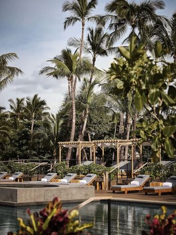 Poolbereich mit Liegen und Palmen im Resort