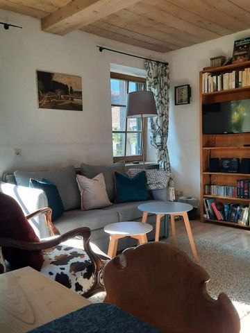 Gemütlicher Wohnraum mit Sesseln und Holzregalen in natürlichem Licht.