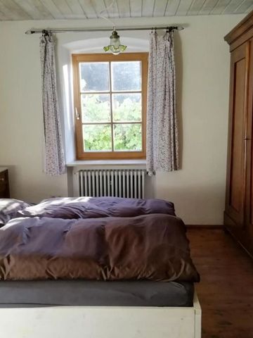 Schlafzimmer mit Doppelbett und rustikalem Holzschrank.