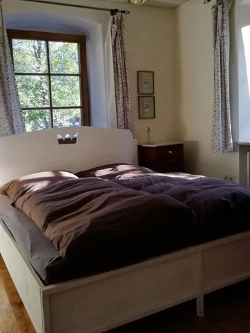 Geräumiges Schlafzimmer mit großem Fenster und Doppelbett.