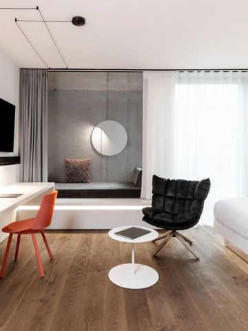 Geräumiges Hotelzimmer mit minimalistischen Möbeln und großen Fenster für viel Licht