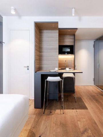 Offenes Zimmerdesign mit Küchenzeile und moderner Einrichtung in hellem Holzton