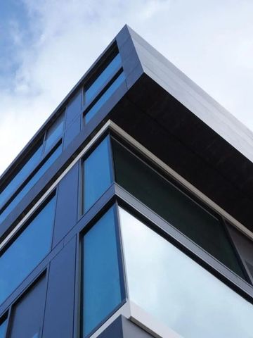 Moderne Architektur des Hotelgebäudes mit Glasfassade und blauem Himmel