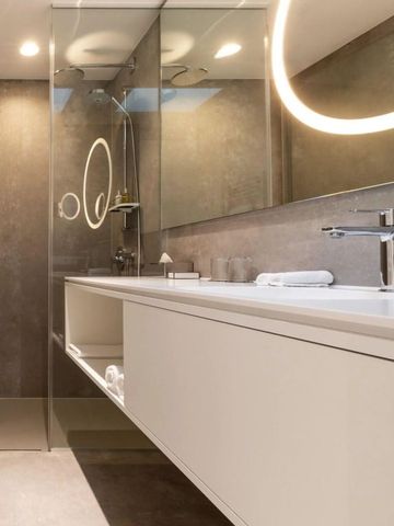 Luxuriöses Badezimmer mit beleuchtetem Spiegel und modernen Armaturen