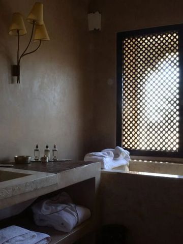 Edles Badezimmer mit orientalischem Fensterdesign und natürlichen Materialien