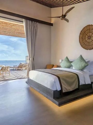 Luxuriöses Schlafzimmer mit Meerblick und Balkon im Kudadoo Maldives.