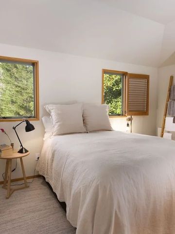 Schlafzimmer mit offenem Fenster und natürlichem Licht auf einem bequemen Bett