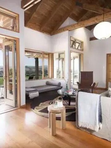 Wohnzimmer mit hohen Decken, Sofa und Zugang zur Terrasse mit Panorama-Ausblick