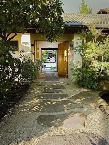 Steinpfad durch einen üppigen Garten mit Blick auf einen Eingang