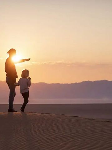 Zwei Personen bei Sonnenuntergang in der Namib-Wüste