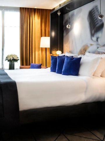 Stilvolles Hotelzimmer mit großen Bett und blauen Akzenten