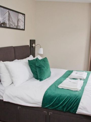 Elegantes Hotelzimmer mit Doppelbett und modernen Details in Grün.