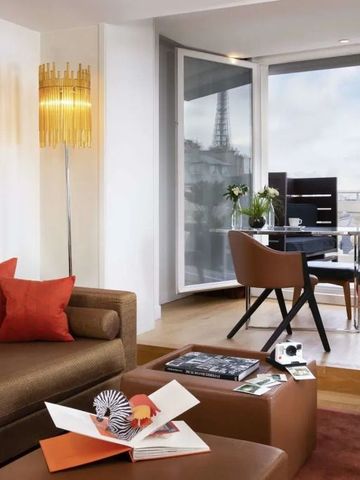 Luxuriöses Wohnzimmer mit Sessel und Aussicht auf die Stadt.