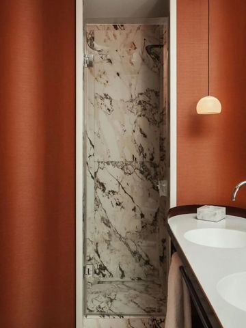 Modernes Badezimmer mit Marmorakzenten und stilvoller Beleuchtung.