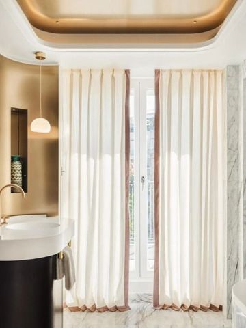 Modernes Badezimmer mit goldenen Akzenten und Naturlicht