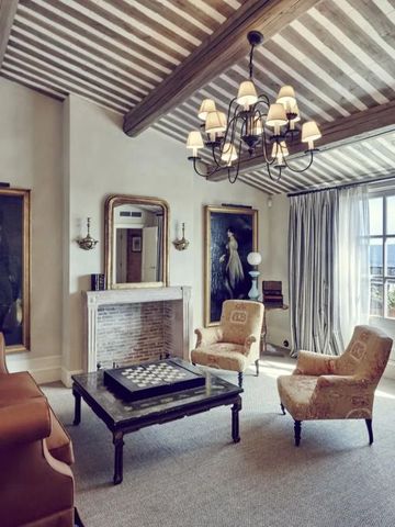 Elegantes Wohnzimmer mit Kamin und antiken Gemälden in Airelles La Bastide de Gordes