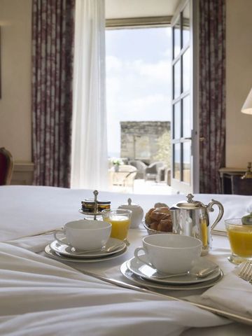 Frühstückstablett auf Bett in einem eleganten Hotelzimmer mit Terrasse in Airelles La Bastide de Gordes
