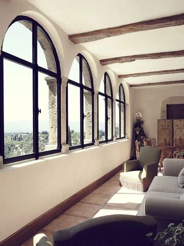 Heller Gang mit Rundbogenfenstern und stilvollen Sitzmöbeln