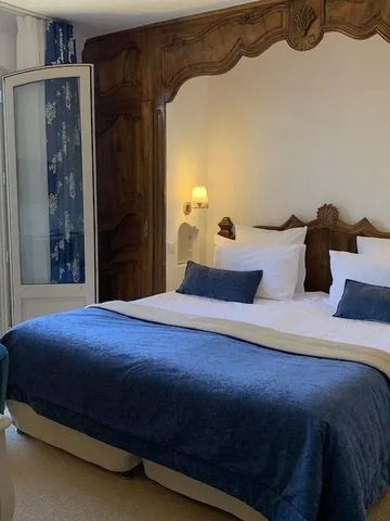 Elegantes Zimmer mit blauen Akzenten und stilvollem Holzkopfteil