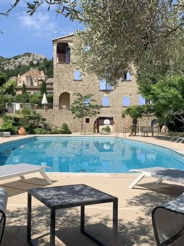 Hotelgebäude mit Pool und umliegender Natur bei blauem Himmel