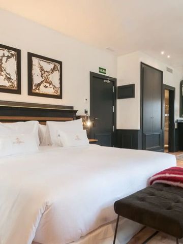 Elegantes Hotelzimmer mit Kingsize-Bett und stilvoller Dekoration