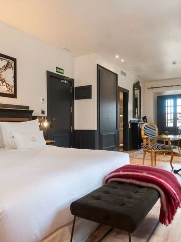 Großzügiges Hotelzimmer mit stilvoller Einrichtung und Sitzbereich