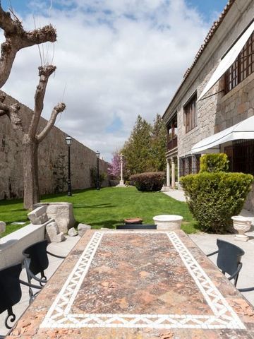 Langer Marmortisch in einem gepflegten Garten vor historischer Mauer