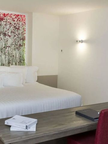 Modernes Hotelzimmer mit Kingsize-Bett und Wandkunst in Coquillade Provence.