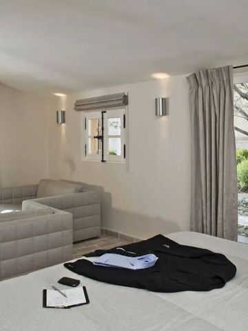 Geräumiges Zimmer mit großer Fensterfront und gemütlicher Sitzecke.