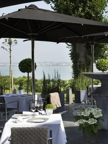 Schattige Terrasse mit Blick auf den See im Restaurantbereich von La Ferme Saint Simeon